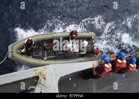 SOUTH CHINA SEA (March 23, 2017) Crew members of the forward-deployed Arleigh Burke-class guided-missile destroyer USS Fitzgerald (DDG 62) lower a rigid hull inflatable boat (RHIB) to conduct a transfer of personnel while underway. Fitzgerald is in the U.S. 7th Fleet area of operations supporting security and stability in the Indo-Asia-Pacific region. Stock Photo