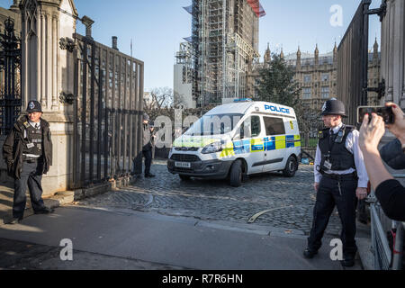 London, UK. 11th December, 2018. An arrested man is driven away through the Palace gates moments after officers tasered the suspect inside the entrance to the grounds of the UK's Houses of Parliament. London's Metropolitan Police confirmed in a statement that the man was 'detained and arrested by Carriage Gates inside the Palace of Westminster on suspicion of trespassing at a protected site.' Credit: Guy Corbishley/Alamy Live News Stock Photo