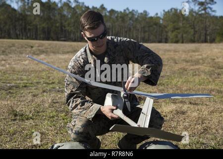 Sgt. Kyle Phillips conducts final checks on a Raven small unmanned aircraft system to make sure the system will respond properly to controls. Marines conducted aerial training exercises at Tactical Landing Zone Dove to demonstrate the capabilities and build familiarization with the SUAS. Phillips is an intelligence specialist with 2nd Battalion, 8th Marine Regiment. Stock Photo