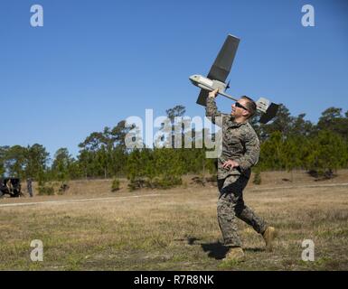 Sgt. Dillon Emery launches a Raven small unmanned aircraft system at Camp Lejeune, N.C., March 27, 2017. Marines conducted aerial training exercises at Tactical Landing Zone Dove to demonstrate the capabilities and build familiarization with the SUAS. Emery is an intelligence specialist with 2nd Battalion, 8th Marine Regiment. Stock Photo