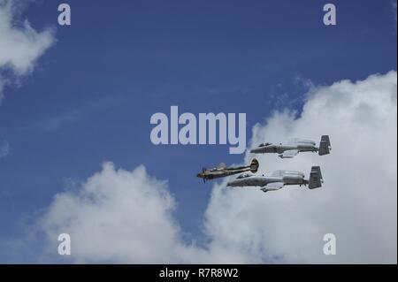 Two U.S. Air Force A-10C Thunderbolt IIs, assigned to the 354th Fighter Squadron and a part of the A-10 West Heritage Flight Team, and a P-38 Lightning fly in formation during the Los Angeles County Air Show in Lancaster, Calif., March 25, 2017. This is the team’s first air show performance after nearly five years of disbandment. Stock Photo