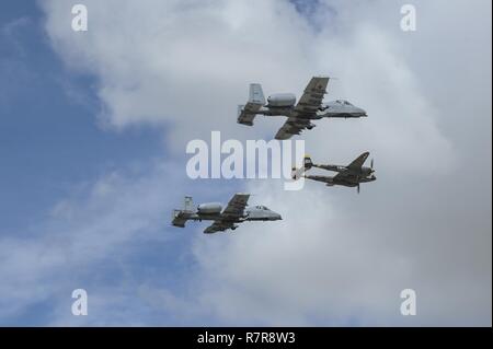 Two U.S. Air Force A-10C Thunderbolt IIs, assigned to the 354th Fighter Squadron and a part of the A-10 West Heritage Flight Team, and a P-38 Lightning fly in formation during the Los Angeles County Air Show in Lancaster, Calif., March 25, 2017. This is the team’s first air show performance after nearly five years of disbandment. Stock Photo