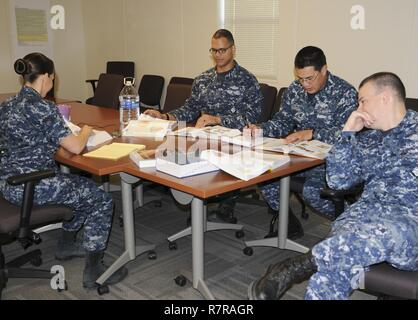 SAN ANTONIO (March 30, 2017) Hospital corpsmen (HM) assigned to the Academics Directorate at Navy Medicine Education, Training and Logistics Command (NMETLC) review material during a meeting as part of the HM 'A' School curriculum rewrite at NMETLC headquarters on board Joint Base San Antonio - Fort Sam Houston, Texas. The curriculum rewrite is part of the Navy surgeon general's readiness priority and is planned to be implemented in the schoolhouse at Fort Sam Houston this July. Stock Photo