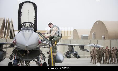 Lt. Col. Craig Andrle, 79th Expeditionary Fighter Squadron commander, climbs down from an F-16 Fighting Falcon as members of the 79th EFS wait to congratulate him on flying his 1,000th combat hour March 20, 2017 at Bagram Airfield, Afghanistan. Andrle reached the milestone while supporting the wing’s counterterrorism mission in Afghanistan. Stock Photo