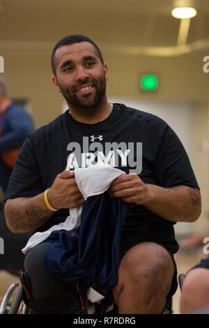 U.S. Army Sgt. Christopher McGinnis, Bethesda, Md., smiles before training for the wheelchair basktetball event for the Warrior Care and Transition's Army Trials at Fort Bliss, Texas, March 31, 2017, 2017. About 80 wounded, ill and injured active-duty Soldiers and veterans are competing in eight different sports 2-6 April for the opportunity to represent Team Army at the 2017 Department of Defense Warrior Games. Stock Photo