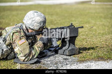U.S. Army Pfc. Julius Forde zeroes his weapon before shooting a weapon qualification during the New York Army National Guard Best Warrior Competition at Camp Smith Training Site March 30, 2017. The Best Warrior competitors represent each of New York's brigades after winning competitions at the company, battalion, and brigade levels. Stock Photo