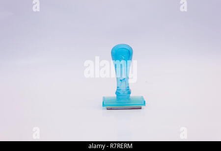 Rubber stamp with blue ink on isolated white background in space office work supply tool Stock Photo