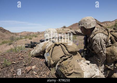 U.S. Marine Corps Lance Cpl. Joel V. Sepulveda, right, a rifleman with 1st Platoon, Echo Company, 2nd Battalion, 6th Marine Regiment, 2nd Marine Division (2d MARDIV), discusses his squad’s position with Pfc. Tanner A. Thatcher, a rifleman, during squad-level attack live fire training at Afghan Alley shooting range on U.S. Army Yuma Proving Grounds for Talon Exercise (TalonEx) 2-17, Yuma, A.Z., March 30, 2017. The purpose of TalonEx was for ground combat units to conduct integrated training in support of the Weapons and Tactics Instructor Course (WTI) 2-17 hosted by Marine Aviation Weapons and  Stock Photo