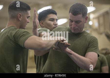 USS SOMERSET, At Sea (March 27, 2017) U.S. Marine Sgt. Scott Ingram, left, walks Sgt. Michael Farrow through the movements to execute a proper shoulder throw during a Marine Corps Martial Arts Program (MCMAP) training session aboard USS Somerset (LPD 25), March 27. MCMAP teaches physical and mental discipline, helping Marines with the 11th Marine Expeditionary Unit (MEU) maintain a combat-ready body and mindset. The 11th MEU provides a sea-based, Marine Air-Ground Task Force capable of conducting a variety of missions from amphibious combat operations to humanitarian assistance. The Marines ar Stock Photo