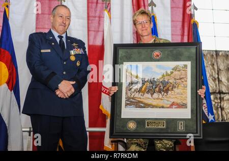 Colorado Army National Guard Brig. Gen. Laura Clellan, Land Component Commander, presents United States Air Force Maj. Gen. H. Michael Edwards, the adjutant general of Colorado, a framed picture depicting the Battle of Glorieta Pass Action at Apache Canyon during his retirement ceremony from the Colorado Air National Guard at Hangar 801 on Buckley Air Force Base, Aurora, Colo., April 2, 2017. Maj. Gen. Edwards dedicated 43-years of military service and was the 42nd Adjutant General of the state of Colorado.  (Air National Guard Stock Photo