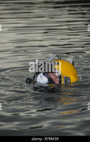 Builder 2nd Class Christian Makin, assigned to Underwater Construction Team 2, awaits instructions prior to a dive in Jinhae, Republic of Korea (ROK), during exercise Foal Eagle April 5, 2017. Foal Eagle is an annual, bilateral training exercise designed to enhance the readiness of U.S. and ROK forces and their ability to work together during a crisis. The Sailors of Construction Dive Detachment Charlie are on the second stop of their deployment where they are conducting inspections, maintenance, and repairs of various underwater and waterfront facilities in support of the Pacific Fleet. Stock Photo