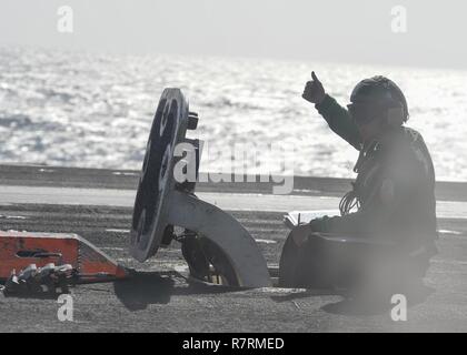 PACIFIC OCEAN (March 31, 2017) Aviation Boatswain's Mate (Equipment) 3rd Class Danilo Navarro gives the clear signal prior to launching an aircraft aboard the aircraft carrier USS Nimitz (CVN 68). The ship is underway conducting a composite training unit exercise with it's carrier strike group in preparation for an upcoming deployment. Stock Photo