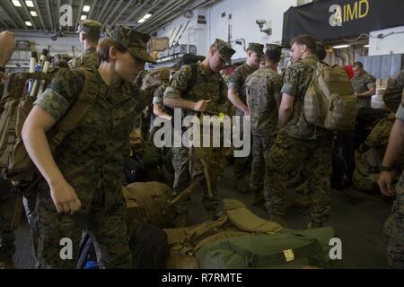 U.S. Marines disembark the USS Bonhomme Richard (LHD 6) after returning from their Spring Patrol of the Asia-Pacific region, April 6, 2017. As the Marine Corps’ only continuously forward deployed unit, the 31st Marine Expeditionary Unit is prepared to respond to a wide range of military operations, from humanitarian assistance missions to limited combat operations, at a moment’s notice. As a balanced air-ground-logistics team, the 31st MEU is ready to respond throughout the Asia-Pacific region. Stock Photo