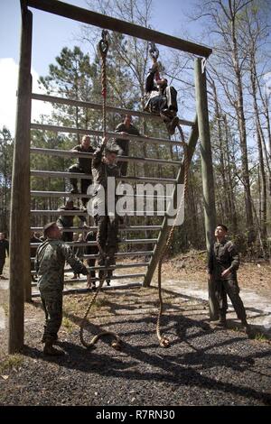 U.S. Marines assigned to Ground Supply School (GSS), Marine Corps Combat Service Support Schools, conduct an obstacle at Camp Johnson, N.C., March 29, 2017. The Marines of GSS ran to three different stations that consisted of either obstacles or buddy drags and fireman carries to ensure combat conditioning and unit cohesion. Stock Photo