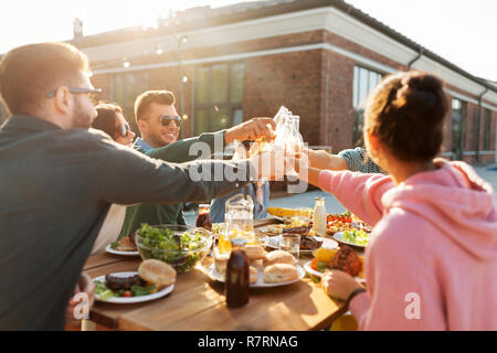 happy friends toasting drinks at rooftop party Stock Photo