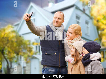 family takes autumn selfie by cellphone over house Stock Photo