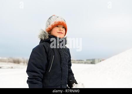 happy little boy in winter clothes outdoors