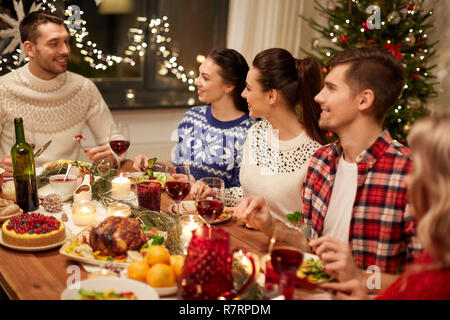 happy friends having christmas dinner at home Stock Photo