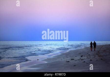 A couple walking on beach after sunset, Djerba, Tunisia Stock Photo