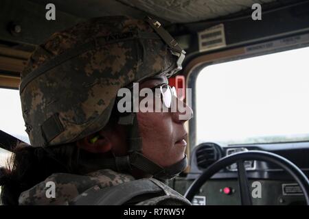 US Army Spc. Jessica Taylor, a civil affairs specialist with the 364th Civil Affairs Brigade, 351st Civil Affairs Command, verifies the status of the machine gunner on her team during a firing exercise as part of Operation Cold Steel at Fort McCoy, Wis., on April 02, 2017. The 351st CACOM is responsible for strategic operations through tactical civil affairs support across the U.S. Pacific Command area of responsibility. Operation Cold Steel is the U.S. Army Reserve’s crew-served weapons qualification and validation exercise to ensure that America’s Army Reserve units and Soldiers are trained  Stock Photo