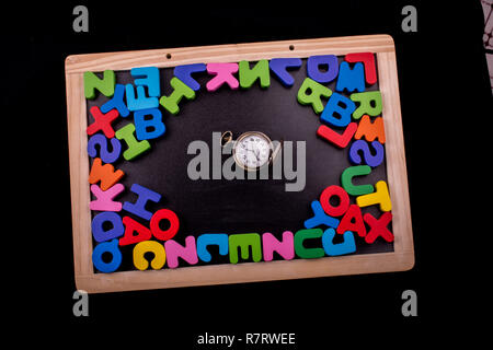 Pocket watch and colorful Letters of Alphabet made of wood Stock Photo