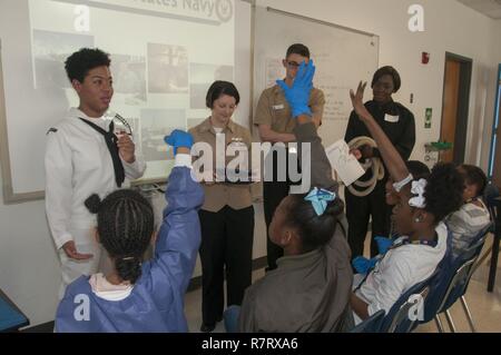 Portsmouth, Va. (April 7, 2017) Students from Park View Elementary School raise their hands after a staff member from Naval Medical Center Portsmouth asks a Navy trivia question. More than a dozen staff members from Naval Medical Center Portsmouth participated in Career Day at the elementary school in Portsmouth by setting up three interactive Science, Technology, Engineering and Math (STEM)-related stations in the school’s science lab. Stock Photo