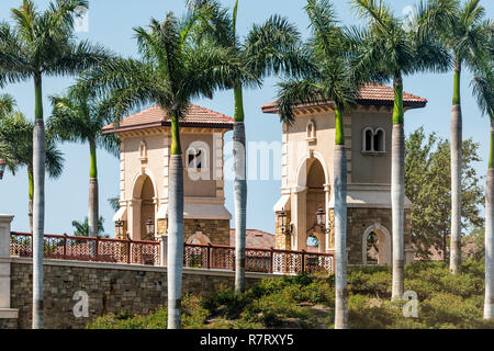 Naples, USA - April 30, 2018: The Peninsula at Treviso Bay gated residential community modern architecture entrance street road in Florida Stock Photo
