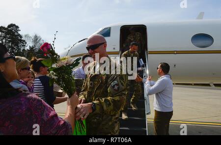 Maj. Jeffrey Aubry, 76th Airlift Squadron pilot, is welcomed home from a six month deployment with flowers on Ramstein Air Base, Germany, April 1, 2017. While deployed, the 76th AS served as the official transportation for the commander of Resolute Support Mission (COMRES), U.S. Army Gen. John W. Nicholson, Jr. Resolute Support Mission is a NATO-led train, advise, and assist mission for the Afghan security forces, consisting of more than 13,000 military service members. Stock Photo