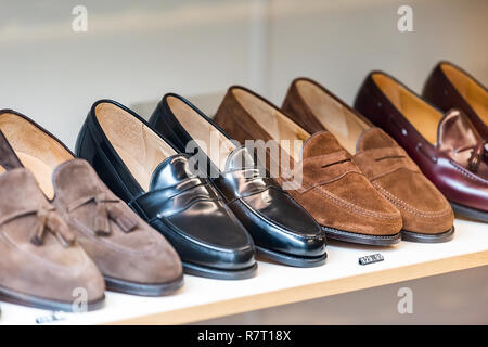 Many pairs of men's oxford English leather traditional shoes on display on store shelf with expensive luxury price in London shop Stock Photo