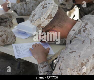 U.S. Marine Corps Cpl. Blake Cannon, a low altitude air defense gunner with 2nd Low Altitude Air Defense Battalion, Marine Air Control Group 28, 2nd Marine Air Wing signs a pre-exposure medical form before volunteering to participate in a tactical demonstration (TACDEMO) of the Active Denial System during Weapons and Tactics Instructor course (WTI) 2-17 at Site 50, Wellton, Ariz., April 4, 2017. The Aviation Development, Tactics and Evaluation Department and Marine Operational Test and Evaluation Squadron One (VMX-1) Science and Technology Departments conducted the TACDEMO to explore and expan Stock Photo