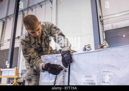 U.S. Staff Sgt. Daniel Cackowski, an air transportation personnel with the 139th Logistics Readiness Squadron, Missouri Air National Guard is trained on how to use a chain gate to secure heavy loads, during deployment field training at Ramstein Air Base, Germany, April 5, 2016. Over 40 Airmen with 139 LRS were working alongside their counterparts from the 86th Air Mobility Wing to enhance their skill levels within their individual career fields. Ramstein Air Base is home to the 86th, 435th and 721st Air Mobility Wings which support three theaters: United States Africa Command, Central Command, Stock Photo