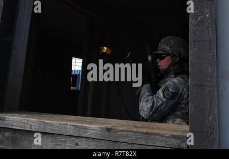 Staff Sgt. Katelyn McHale, 569th U.S. Forces Police Squadron desk sergeant, posts at a window to watch for opposing forces during the urban operations portion of the 435th Security Forces Squadron’s Ground Combat Readiness Training Center’s Security Operations Course on U.S. Army Garrison Baumholder, Germany, April 4, 2017. McHale and other students had a mission to tactically enter a mock village, gain intelligence from the village leader, and make it back to their base. Airmen assigned to the 86th SFS, 422nd SFS, 100th SFS, and 569th USFPS participated in the course. Stock Photo