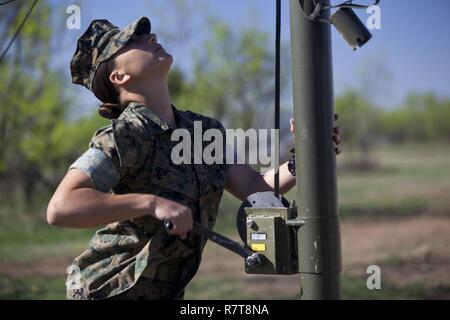 U.S. Marine Corps Pfc. Sydney I. Munn, a student assigned to the Tactical Signals Intelligence Operators Course, Marine detachment Goodfellow, sets up a 8 Meter Collapsable Mast Assembly at Joint Airforce Base Goodfellow, Texas, March 24, 2017. The mission of Marine Detachment Goodfellow is to train Marines in the occupational fields of Fire Protection and Signals Intelligence for the Fleet Marine Force. Stock Photo