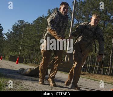 U.S. Army Sgt. 1st Class Dustin Oliveira and 1st Lt. Joseph Lemens, 7th Infantry Division Rangers, pull a litter during the Best Ranger Competition 2017 in Fort Benning, Ga., April 7, 2017. The 34th annual David E. Grange Jr. Best Ranger Competition 2017 is a three-day event consisting of challenges to test competitor's physical, mental, and technical capabilities. Stock Photo