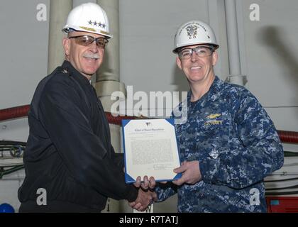 YOKOSUKA, Japan (April 7, 2017) Adm. Scott H. Swift, Commander, U.S. Pacific Fleet, presents Capt. Buzz Donnelly, commanding officer of the Navy's only forward-deployed aircraft carrier, USS Ronald Reagan (CVN 76), with a Meritorious Unit Commendation (MUC) award during an all-hands call in the ship's hangar bay. Former Secretary of the Navy John T. McNaughton established the MUC award in 1967 to recognize units which display valorous or meritorious achievement. Ronald Reagan, the flagship of Carrier Strike Group 5, provides a combat-ready force that protects and defends the collective maritim Stock Photo