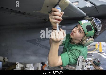 ARABIAN GULF (April 3, 2017) Aviation Electronics Technician Airman Trista Mahoney seals an antenna on the wing of an F/A-18F Super Hornet attached to the 'Blacklions' of Strike Fighter Squadron (VFA) 213 aboard the aircraft carrier USS George H.W. Bush (CVN 77) (GHWB). GHWB is deployed in the U.S. 5th Fleet area of operations in support of maritime security operations designed to reassure allies and partners, and preserve the freedom of navigation and the free flow of commerce in the region. Stock Photo