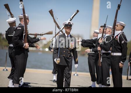 WASHINGTON, DISTRICT OF COLUMBIA -Yeoman Chief Petty Officer Brian Tolentino, a sailor with the United States Navy's Ceremonial Guard walks through two rows of spinning rifles and bayonets during the Joint Service Drill Team Exhibition April 08, 2017, at the Jefferson Memorial in Washington, D.C. Drill teams from all four branches of the U.S. armed forces and the U.S. Coast Guard competed in a display of  skills at the event that celebrated U.S. military heritage at the National Cherry Blossom Festival.     Members of the Navy Ceremonial Guard participate in some of our nation’s most prestigio Stock Photo