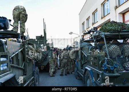 British Soldiers conduct preventive checks on their vehicles at a Czech Republic stop during the Battle Group Poland convoy, March 25, 2017. The convoy, which also has U.S. Soldiers, is in route to Orzysz, Poland where they will integrate with the Polish and Romanian Soldiers for a six month rotation for NATO’s Enhanced Forward Presence. NATO's eFP is an allied, forward deployed defense and deterrence posture in Eastern Europe to protect and reassure NATO's Eastern member states of their security. Stock Photo