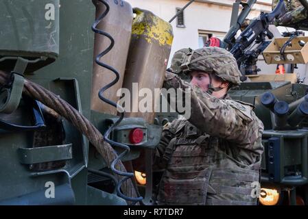 U.S. Army Spc. Bert L. Bradley, with the 2nd Squadron, 2nd Cavalry Regiment, conducts preventive checks on his vehicle at a Czech Republic stop during the Battle Group Poland convoy, March 25, 2017. The convoy, which also has British Soldiers is in route to Orzysz, Poland where they will integrate with the Polish and Romanian Soldiers for a six month rotation for NATO’s Enhanced Forward Presence. NATO's eFP is an allied, forward deployed defense and deterrence posture in Eastern Europe to protect and reassure NATO's Eastern member states of their security. Stock Photo