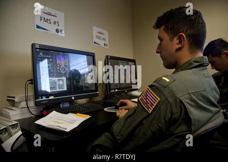 U.S. Naval officers assigned to the Basic Flight Training Course, Training Air Wing Four, practice on a flight management system at Naval Air Station Corpus Christi, Texas, March 20, 2017. The mission of Training Air Wing Four is to provide basic flight training as well as intermediate and advanced flight training using multi-engine aircraft. Stock Photo