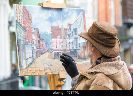 Artist painting street scene at High Street Winchester, Hampshire, UK in December Stock Photo