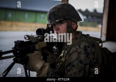 U.S. Marine Lance Cpl. Jack L. Farewell III, an infantryman with Marine Rotational Force Europe 17.1 (MRF-E), posts security during squad-attack drills in Vaernes Garnison, Norway, April 7, 2017. MRF-E Marines' training varies from military operations in urban terrain to squad-level patrols. Marines with MRF-E keep skills sharp as the forward deployed element in Europe. Stock Photo