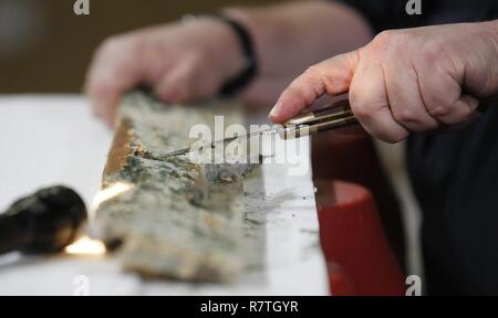 U.S. Customs and Border Protection, Office of Field Operations, Agriculture Specialist John Taylor inspects wood packaging material (WPM) for the presence of live wood boring insect larvae as he and team members of the National Agriculture Cargo Targeting Unit search imports at the Port of Baltimore in Baltimore, Md., April 4, 2017. U.S. Customs and Border Protection Stock Photo