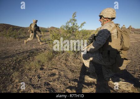 U.S. Marine Corps Lance Cpl. Cody L. Brunell, right, a combat engineer with 1st Platoon, Golf Company, 2nd Battalion, 6th Marine Regiment, 2nd Marine Division (2d MARDIV), directs Marines through a breach of enemy concertina wire during platoon-level attack live fire training at Graze shooting range on U.S. Army Yuma Proving Grounds for Talon Exercise (TalonEx) 2-17, Yuma, A.Z., April 4, 2017. The purpose of TalonEx was for ground combat units to conduct integrated training in support of the Weapons and Tactics Instructor Course (WTI) 2-17 hosted by Marine Aviation Weapons and Tactics Squadron Stock Photo