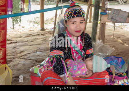 Chiang Mai, Thailand - February 02, 2018: Portrait of a young woman with her baby in ‘Long Neck Karen’ ethnic hill-tribe village, Chiang Mai, Thailand Stock Photo