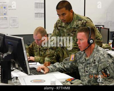 303rd Maneuver Enhancement Brigade Soldiers - Cpt. Thomas Hacker (left), Cpt. Allen Gervico (middle), and Lt. Col. Gordon Knowles (right), prepare for a commander’s update brief during their participation in a warfighter exercise (WFX) hosted by the 25th Infantry Division at Mission Training Complex – Hawaii, Schofield Barracks, April 4, 2017. The exercise ran from April 3-12. It was the first time the 303rd MEB participated in a WFX since its activation just 4 years ago. As the only MEB in the Pacific region, the WFX enhances training to provide for proficiency in the Brigade’s full mission c Stock Photo