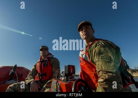 Sgt. Caleb Hubbard (right) and Spc. Dylan Nice, U.S. Army Reserve watercraft operator Soldiers from the 949th Transportation Company, a unit which specializes in watercraft operations, cargo and watercraft engineering, ride on a rescue boat for a series of portraits and images depicting their military occupation specialties in Baltimore, Md., on April 7-8, 2017. Stock Photo