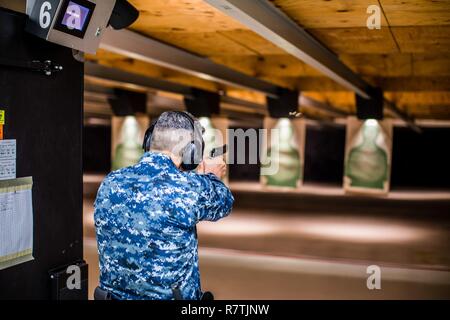 PATUXENT RIVER, Maryland (April 2, 2017) - Lt. Cmdr. Kelly Cruz, Navy Reserve Naval Security Force (NR-NSF) Patuxent River officer-in-charge, fires the M9 pistol during a range qualification at NAS Patuxent River.   The Reservists, headquartered at Navy Operational Support Center Baltimore, augment the active duty police force at NAS Patuxent River and qualify on the same equipment and range as the active duty component. Stock Photo