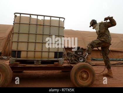 Staff Sgt. Julian Johnson, 768th Expeditionary Air Base Squadron NCO in charge of Heating Ventilation and Air Conditioning, pulls the starting cord for a pressure washer at Nigerien Air Base 101, Niger, April 3, 2017. As part of a two-man team, Johnson helps oversee approximately 120 HVAC units that supply air conditioning to U.S. facilities on the base. Stock Photo