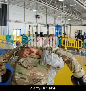 U.S. Army Sgt. Jonathan Johnson, assigned to the SHAPE Band, passes the clinch drill, during which he has to hold his opponent in order to stop incoming punches, for a combatives level one class taught on Chièvres Air Base, Belgium, March 22, 2017. AFNORTH Battalion, USANATO Brigade led this class open to military forces stationed in the Benelux. Stock Photo